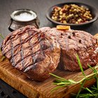 Butcher cutting beef meat on a wooden table