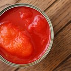 Tomato soup in a black bowl on grey stone background. Top view. Copy space.