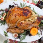 baked whole chicken with oranges on plate. horizontal top view