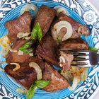 Fried liver with onions and apples on a concrete background