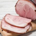 Raw pork knuckle, garlic and lettuce leaves on a cutting board. Selective focus. Ready for cooking.