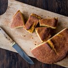 Roasted corn on the cob sitting on wood serving dish