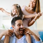 Young happy family with nurse looking down at their newborn in the hospital nursery