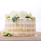 Strawberry cake in a white serving dish on a wooden surface