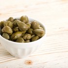 marinated cornichons in wooden bowl