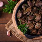 Fried liver with onions and apples on a concrete background