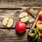 Ripe peaches in a bowl on wooden background