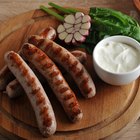 grilled bratwurst sausages with sauce, spinach and garlic