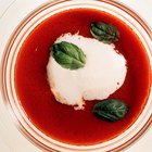 wooden spoon with tomato salsa and a basil leaf