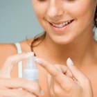 Close-up of a woman's hand applying lotion to her shoulder