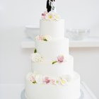 high angle view of a bride and groom cutting the wedding cake