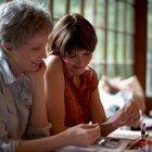 Mother talking on cell phone in kitchen with son