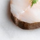 Close-up of a cod fillet with rosemary on a plate