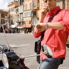 Mid adult man standing at street, looking at watch