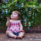 Family looking down at baby boy (0-3 months) in christening gown