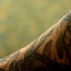 Portrait of smiling tattooed man with arms crossed