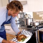 smiling father and daughter taking cake from oven