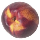 Fresh organic peaches in wooden crate viewed from above