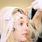 Close-up of a female hairdresser dyeing a mid adult woman's hair