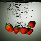 Strawberry cake in a white serving dish on a wooden surface