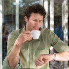 Mid adult man standing at street, looking at watch