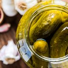 marinated cornichons in wooden bowl