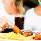 man holds burger with hands and sweet potato fries