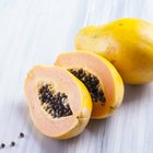 A halved papaya on a wooden table.