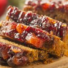 Fresh baked fruitcake for Christmas on plate and spruce branches on boards