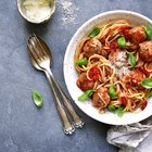 wooden spoon with tomato salsa and a basil leaf