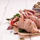 Raw chicken leg on cutting board on wooden background