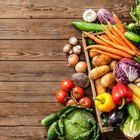 farmer holding box with fresh organic vegetables