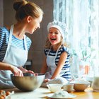 happy family in kitchen. mother and child preparing batter, bake cake