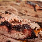 Closeup meat steel pan with spices ready to cook table