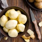 Peeling potatoes on the wooden table horizontal