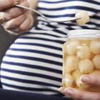 Pregnant woman standing near cradle