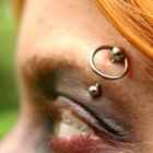 Young woman with nose studs and wearing studded ring, extreme close-up