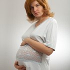 Doctor taking blood pressure of pregnant woman as husband watches