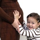 Pregnant woman lying down talking to her doctor