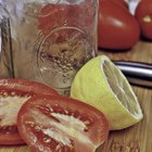 Whole canned tomatoes in brown bowl on wood.