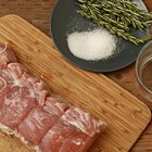 Raw chicken leg on cutting board on wooden background