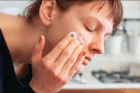 Woman Washing Face with a Sponge