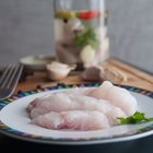 Close-up of a cod fillet with rosemary on a plate