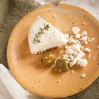 fresh ricotta in olive wood bowl on old table