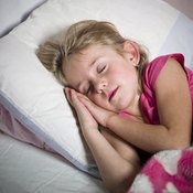 A young girl sleeping in her bed