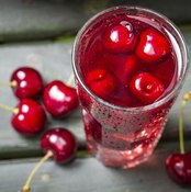Tall glass of cherry juice.
