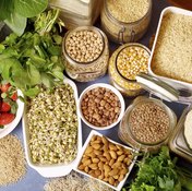 An overhead view of various types of rice, legumes, grains, fruits, vegetables and nuts.