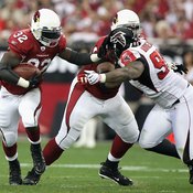 With the blocker angling his defender to the left, Cardinals running back Edgerrin James cuts to his right in a 2009 NFC playoff contest.