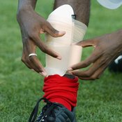 Damarcus Beasley of the Chicago Fire adjusts his shin guard.