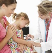 mother holding daughter for doctor